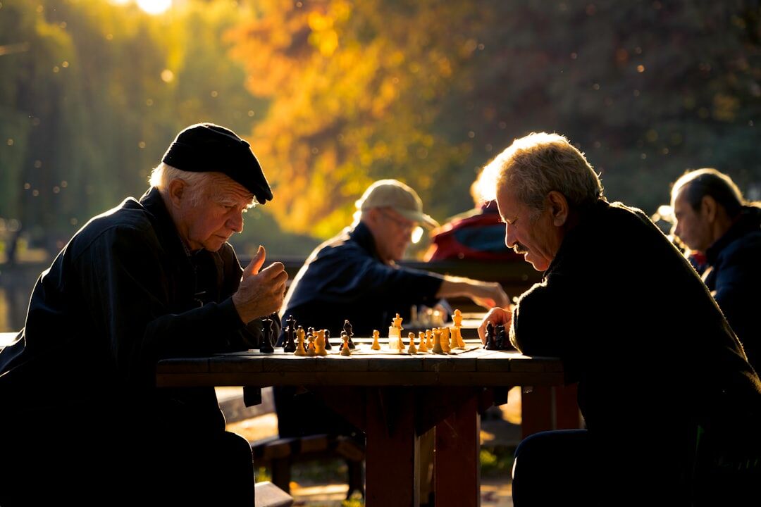 Seniors playing chess and chatting at a community center table